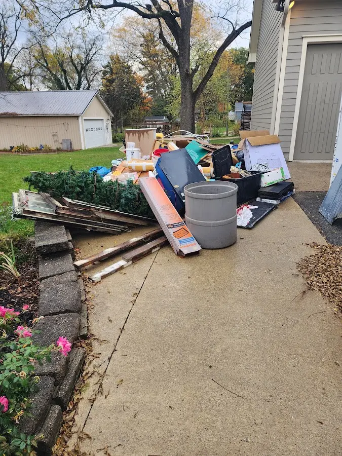Dumpster being loaded with debris for Estate Cleanout Dumpster Rental in Gun Plain